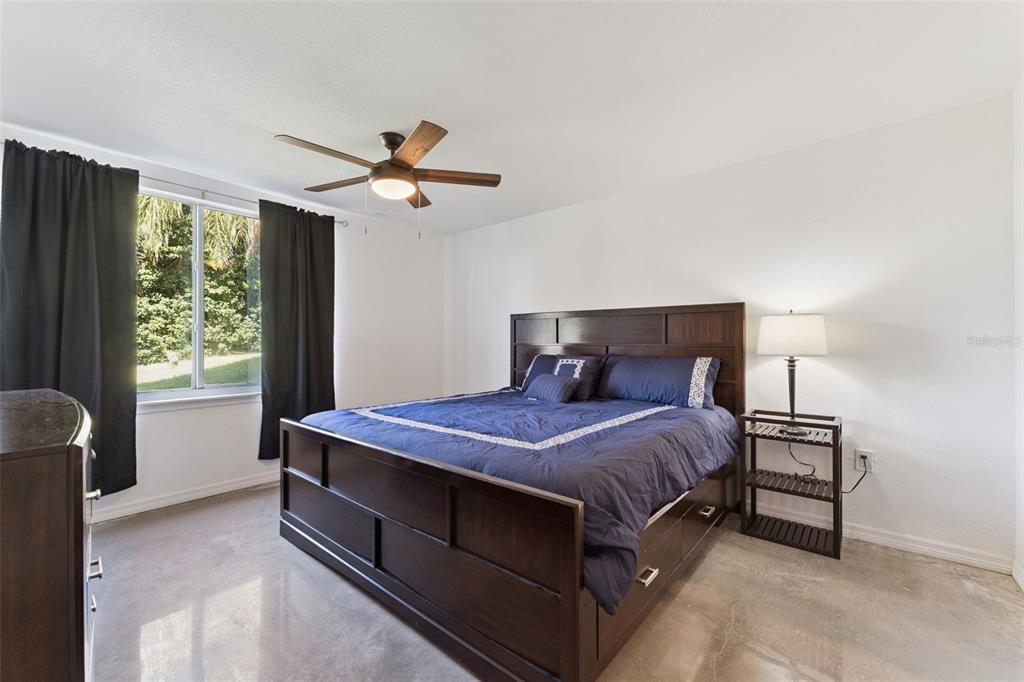 12736 Lake Ridge Circle Clermont, FL 34711 - Photo 49 of 56 a bedroom with a bed and a chandelier