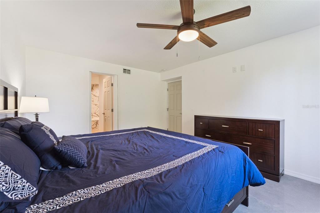 12736 Lake Ridge Circle Clermont, FL 34711 - Photo 50 of 56 a bed room with a bed and a ceiling fan