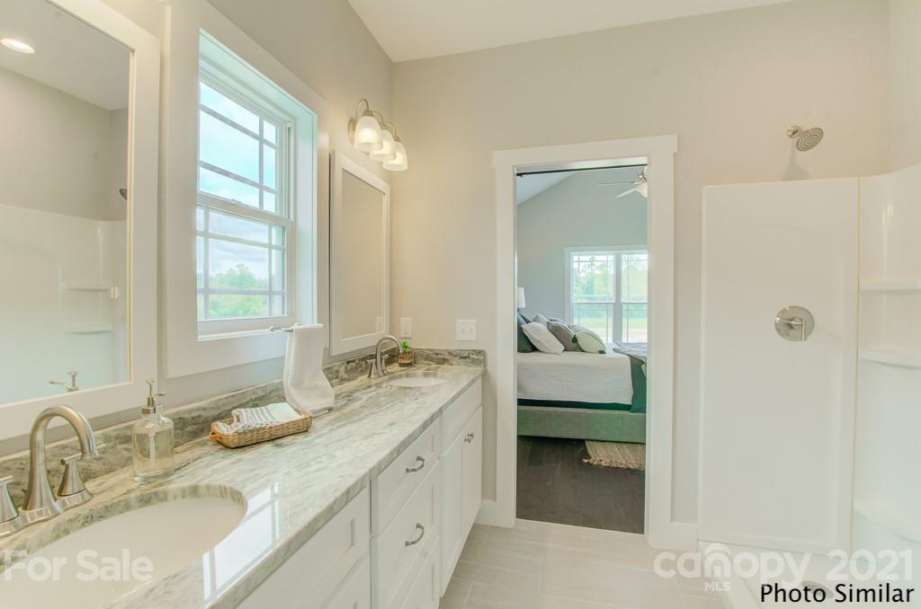 175 Hayes Rdg Lane, Unit 8 Mills River, NC 28759 - Photo 14 of 18 a en suite bathroom with a granite countertop sink and a mirror