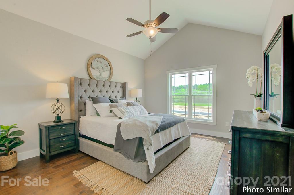 175 Hayes Rdg Lane, Unit 8 Mills River, NC 28759 - Photo 10 of 18 a large bed sitting in a bedroom next to a window and a chandelier