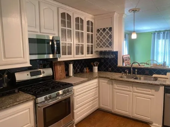 a kitchen with a stove and white cabinets