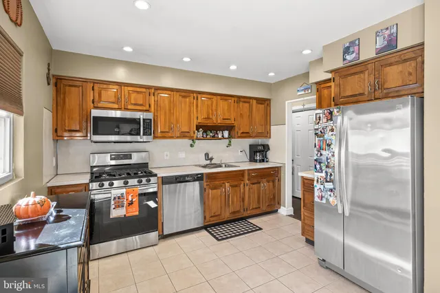 a kitchen with stainless steel appliances granite countertop a refrigerator and a stove top oven