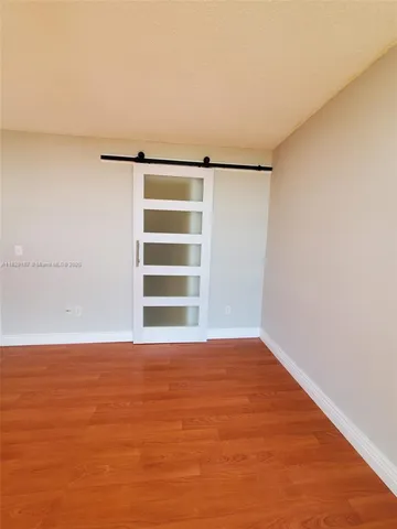 an empty room with wooden floor and closet