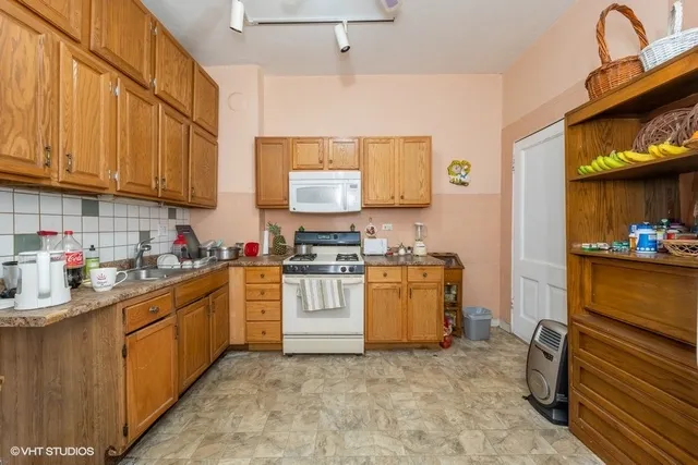 a kitchen with stainless steel appliances granite countertop a stove a sink and a refrigerator