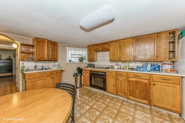 a kitchen with stainless steel appliances granite countertop a stove a sink dishwasher and a refrigerator with wooden cabinets