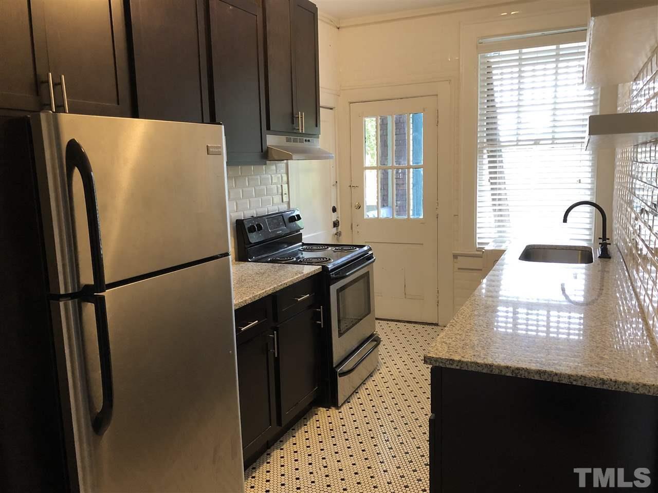 200 East Edenton Street, Unit 4 Raleigh, NC 27601 - Photo 7 of 17 a kitchen with granite countertop a refrigerator a sink a stove and a window