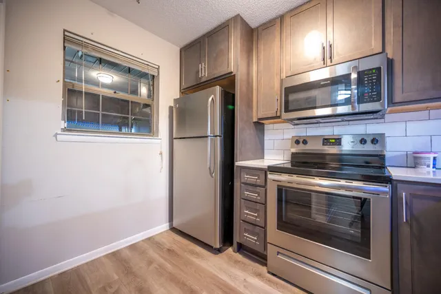 a kitchen with stainless steel appliances a stove microwave and refrigerator