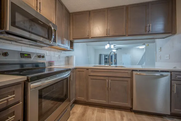 a kitchen with granite countertop cabinets stainless steel appliances and sink