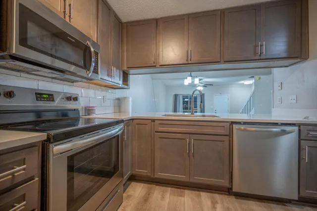 a kitchen with granite countertop cabinets stainless steel appliances and sink