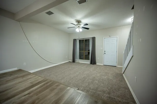 en empty room with fan and a ceiling fan