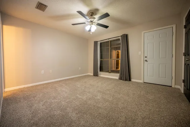 an empty room with closet and ceiling fan
