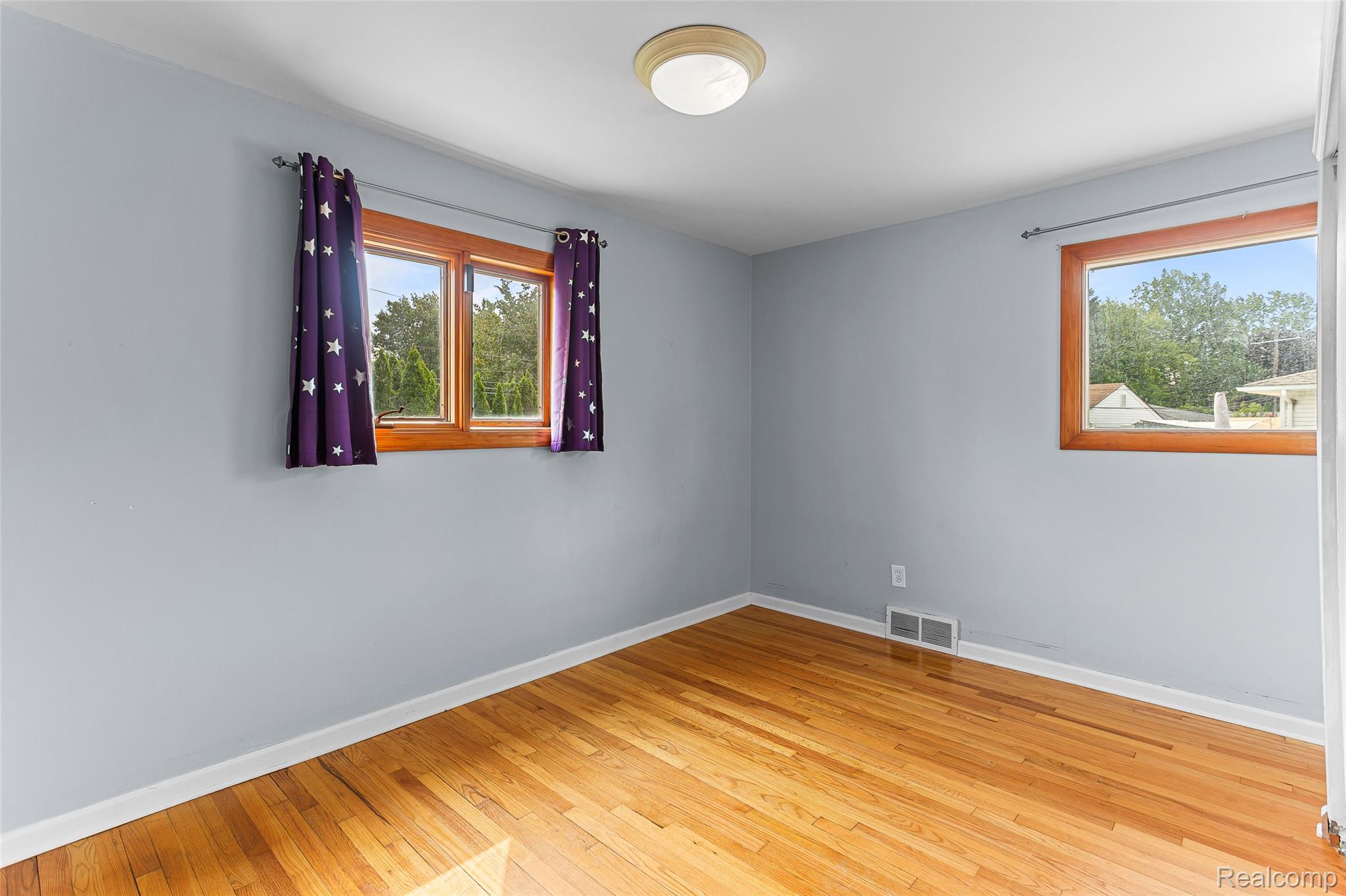 2345 Middlefield Road Trenton, MI 48183 - Photo 17 of 42 Hardwood flooring throughout featuring light gray walls, white trim, and two windows with wood frames