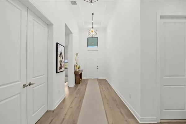 a view of a hallway with wooden floor and staircase