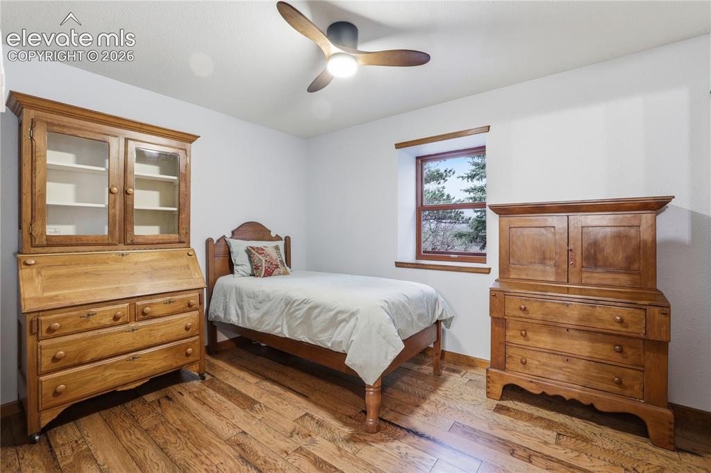 18190 Forest View Road Monument, CO 80132 - Photo 32 of 50 a bedroom with a bed and wooden floor