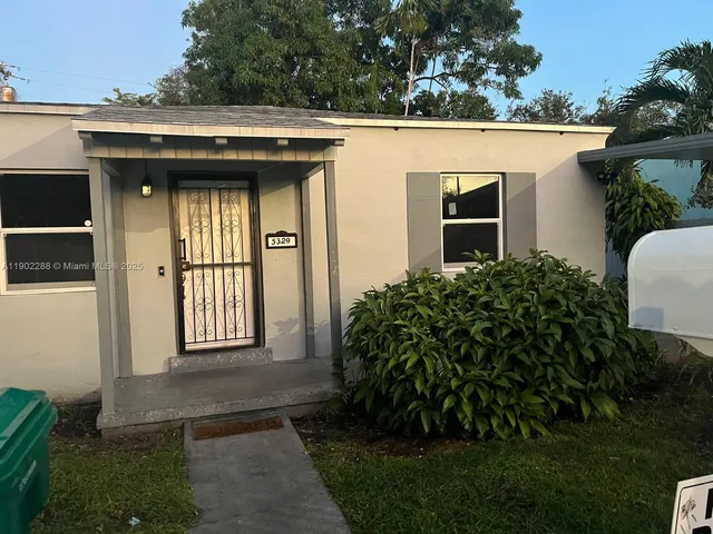 a view of a house with many windows and plants