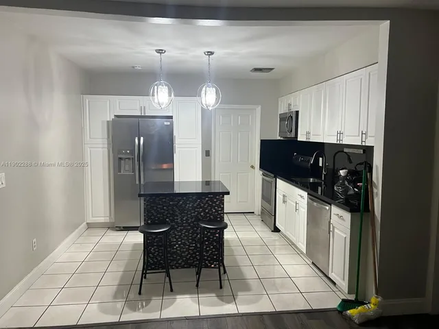 a kitchen with stainless steel appliances a refrigerator and a stove top oven