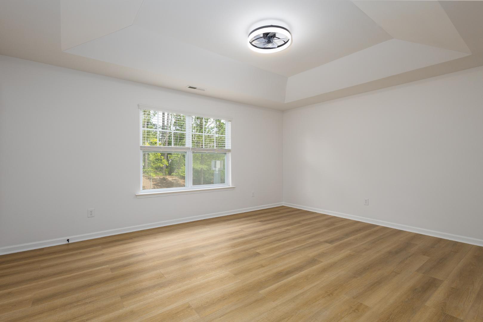 228 Skyros Loop Cary, NC 27519 - Photo 22 of 29 an empty room with wooden floor and windows