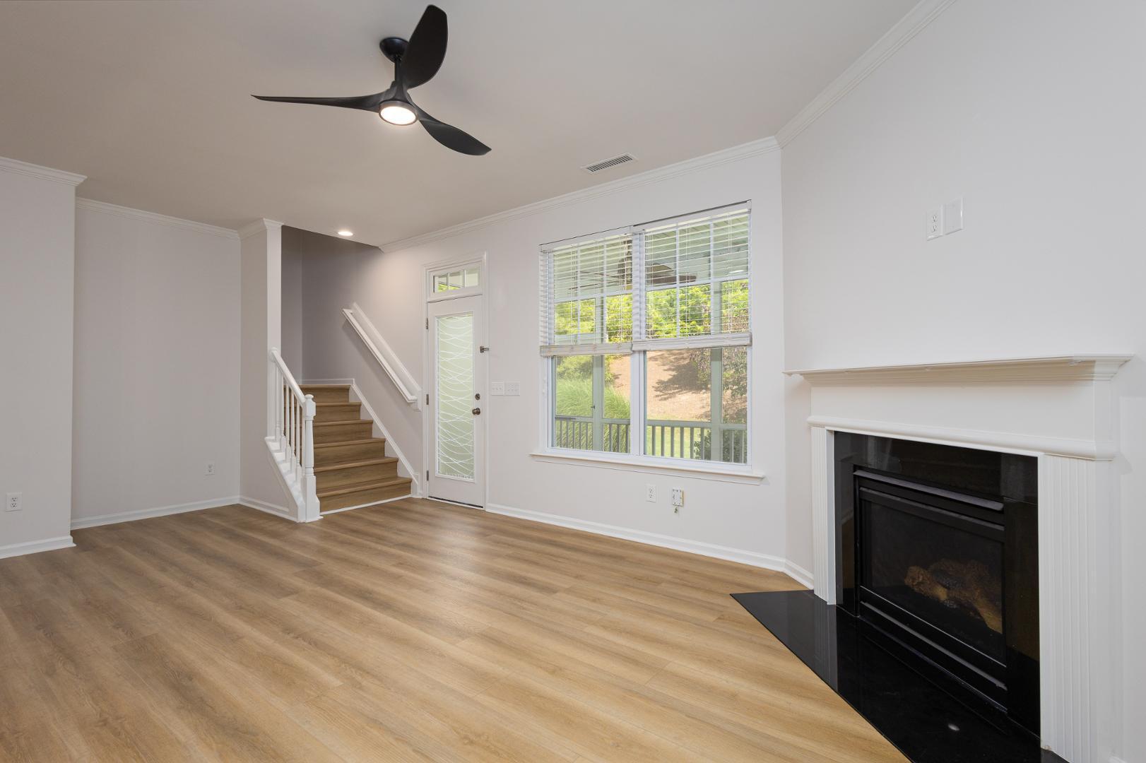 228 Skyros Loop Cary, NC 27519 - Photo 5 of 29 a view of an empty room with wooden floor fireplace and a window