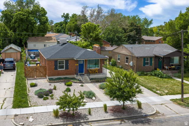 961 33rd Street Ogden, UT 84403 - Photo 1 of 39 Brick facade home featuring a contrasting blue entry door, dark roof shingles, and a front yard with gravel landscaping