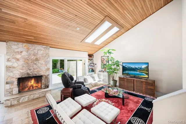 a living room with furniture a flat screen tv and a fireplace