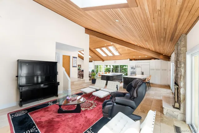 a living room with furniture a flat screen tv and a floor to ceiling window