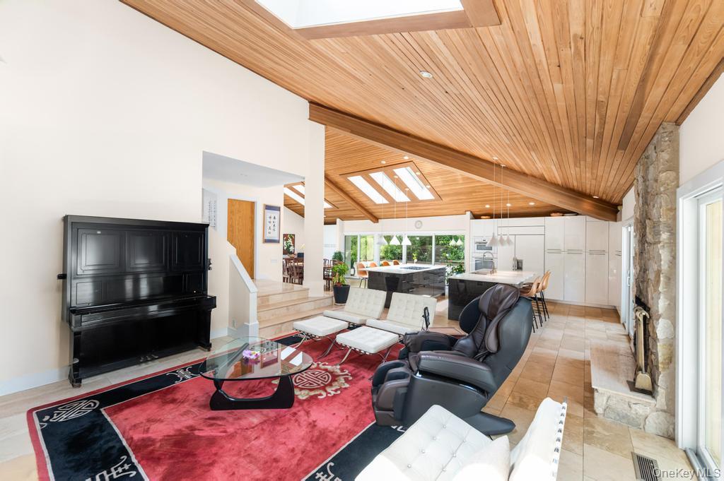2222 Noyack Road Sag Harbor, NY 11963 - Photo 18 of 47 a living room with furniture a flat screen tv and a floor to ceiling window