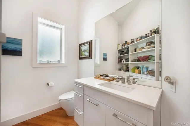 a bathroom with a sink a toilet and mirror