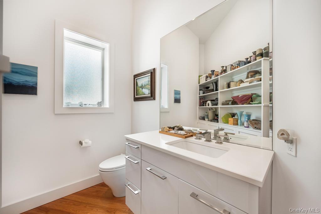 2222 Noyack Road Sag Harbor, NY 11963 - Photo 25 of 47 a bathroom with a sink a toilet and mirror