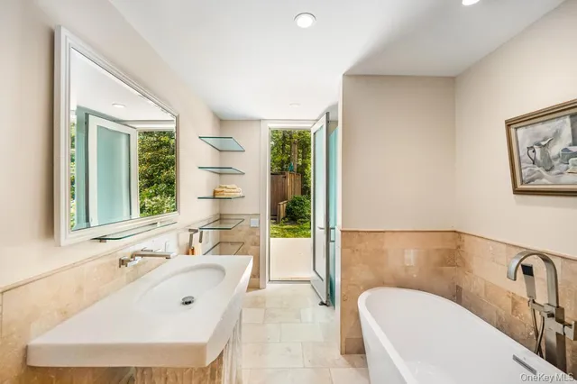 a bathroom with a tub sink and mirror