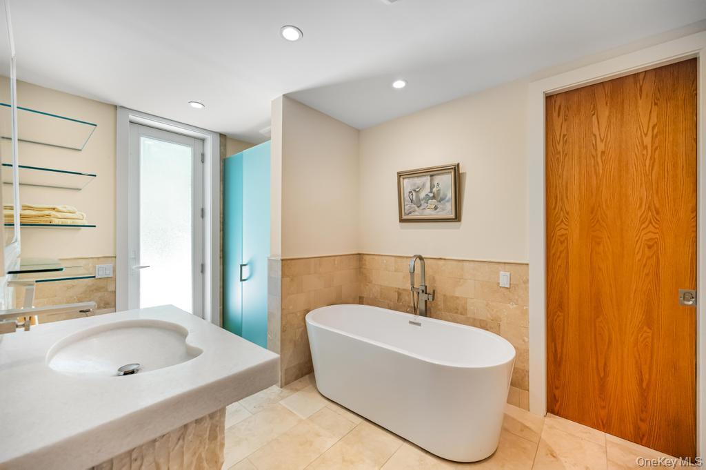 2222 Noyack Road Sag Harbor, NY 11963 - Photo 29 of 47 a bathroom with a tub a sink and a window