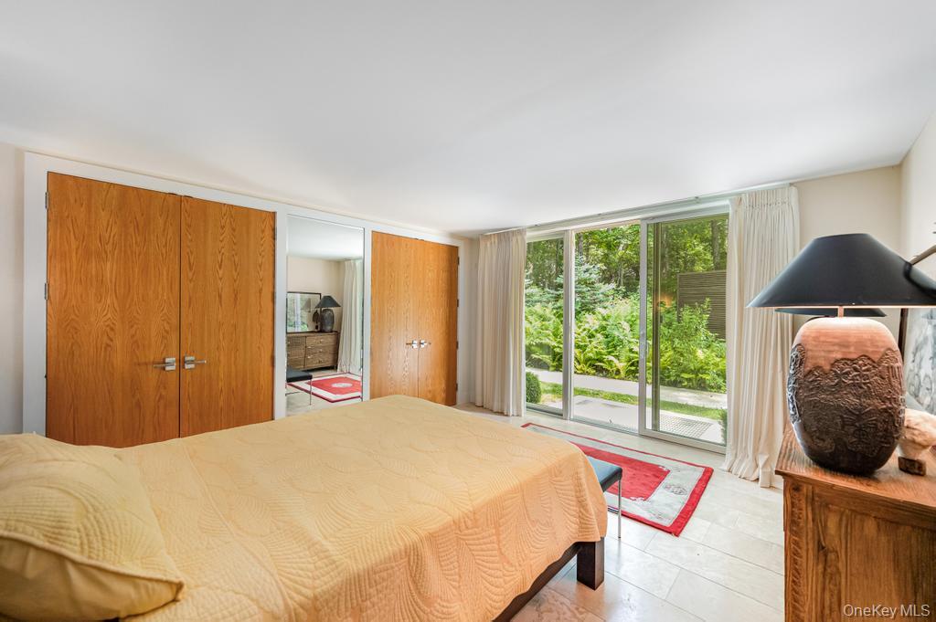 2222 Noyack Road Sag Harbor, NY 11963 - Photo 30 of 47 a bedroom with a bed and glass window