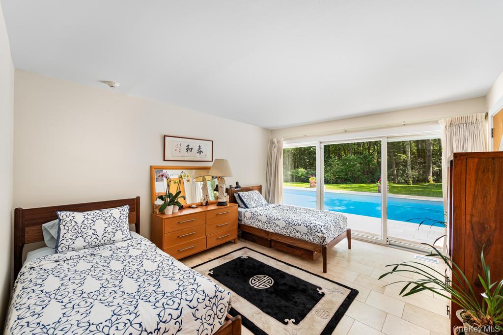 2222 Noyack Road Sag Harbor, NY 11963 - Photo 31 of 47 a bedroom with a bed and glass window