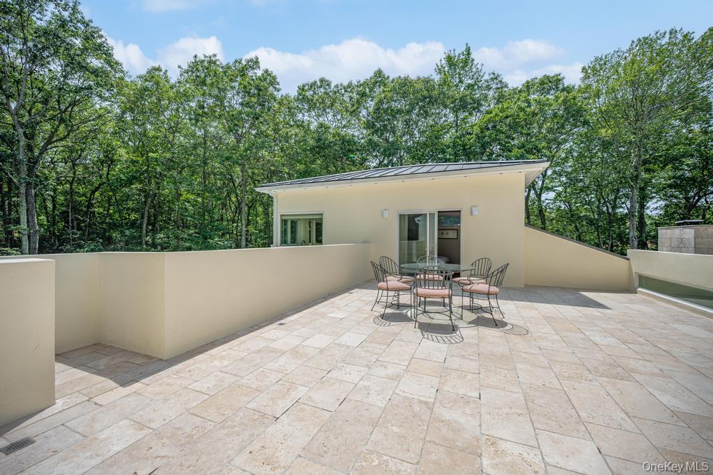 2222 Noyack Road Sag Harbor, NY 11963 - Photo 34 of 47 a view of a patio with table and chairs and potted plants