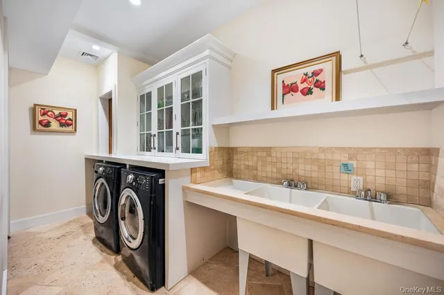 a utility room with cabinets dryer and washer