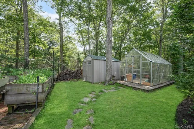 a view of a backyard with plants and a bench