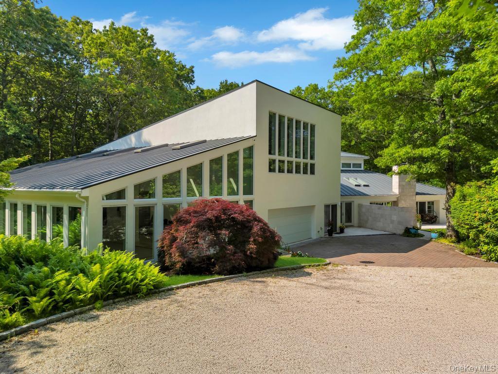 2222 Noyack Road Sag Harbor, NY 11963 - Photo 5 of 47 a front view of a house with a garden