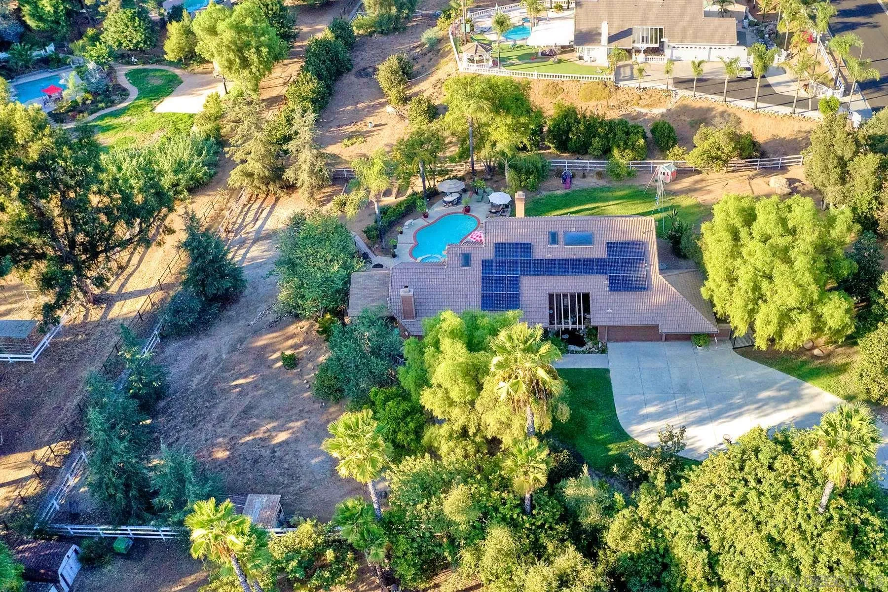 an aerial view of a house with a garden and lake view