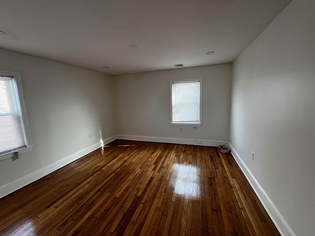 8 Winborough Street Boston, MA 02136 - Photo 9 of 12 an empty room with wooden floor and windows
