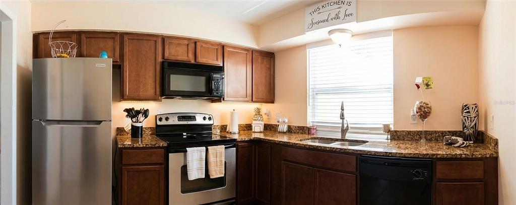 7327 Abonado Road, Unit 7327 Tampa, FL 33615 - Photo 4 of 9 a kitchen with a sink a refrigerator and a stove top oven