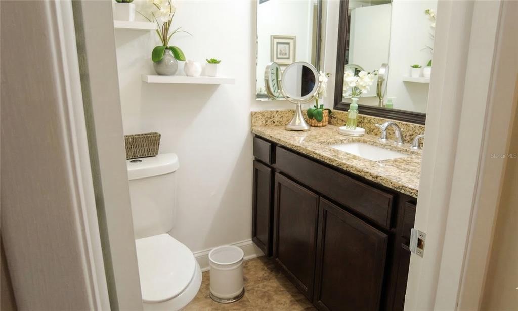 7327 Abonado Road, Unit 7327 Tampa, FL 33615 - Photo 6 of 9 a bathroom with a granite countertop sink toilet and mirror