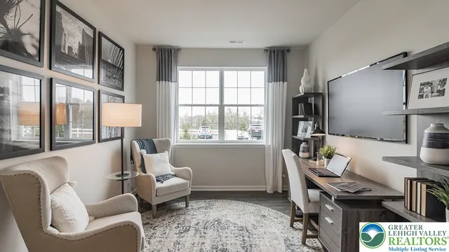 a living room with furniture floor to ceiling window and a flat screen tv