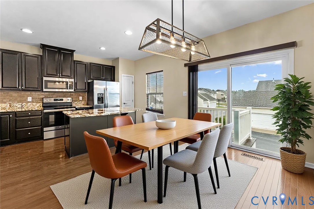 7809 Chasing Lane Richmond, VA 23237 - Photo 7 of 23 a dining room with stainless steel appliances kitchen island granite countertop a dining table chairs and granite counter tops