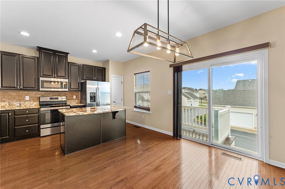 7809 Chasing Lane Richmond, VA 23237 - Photo 8 of 23 a kitchen with stainless steel appliances granite countertop a refrigerator a stove top oven a sink with wooden floor and cabinets
