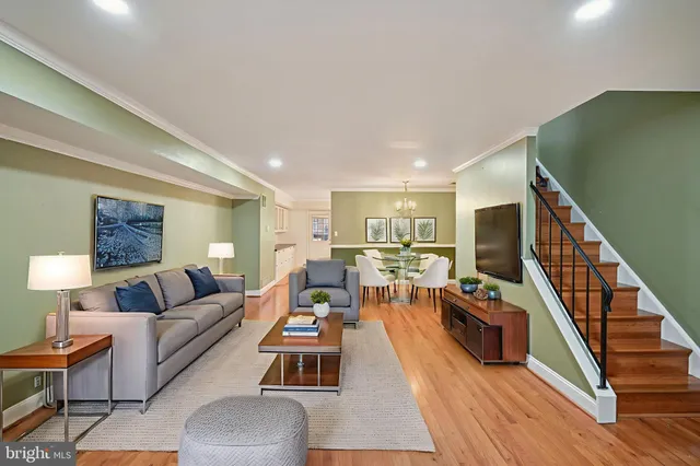 a living room with furniture flat screen tv and a wooden floor