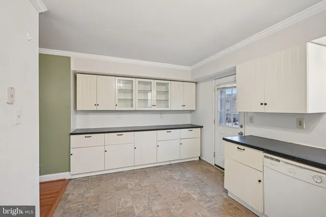 a kitchen with granite countertop white cabinets and sink