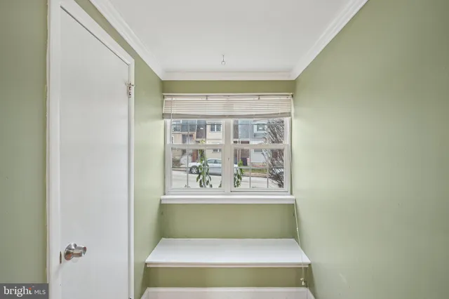a white painted room with a couch and window