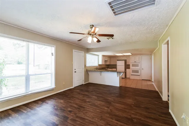 a kitchen view with wooden floor and a window