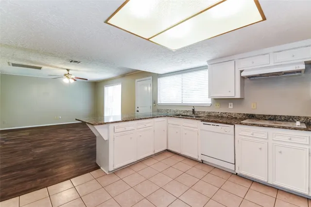 a kitchen with granite countertop white cabinets and white appliances