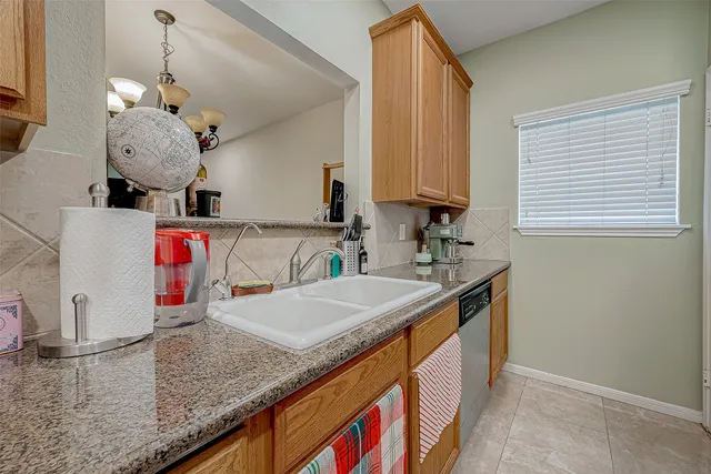 a kitchen with stainless steel appliances granite countertop a sink dishwasher and cabinets with wooden floor