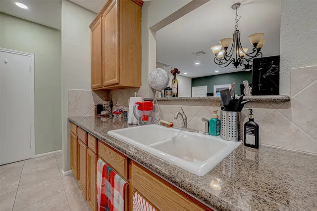 a kitchen with stainless steel appliances granite countertop a sink a stove and a wooden floor